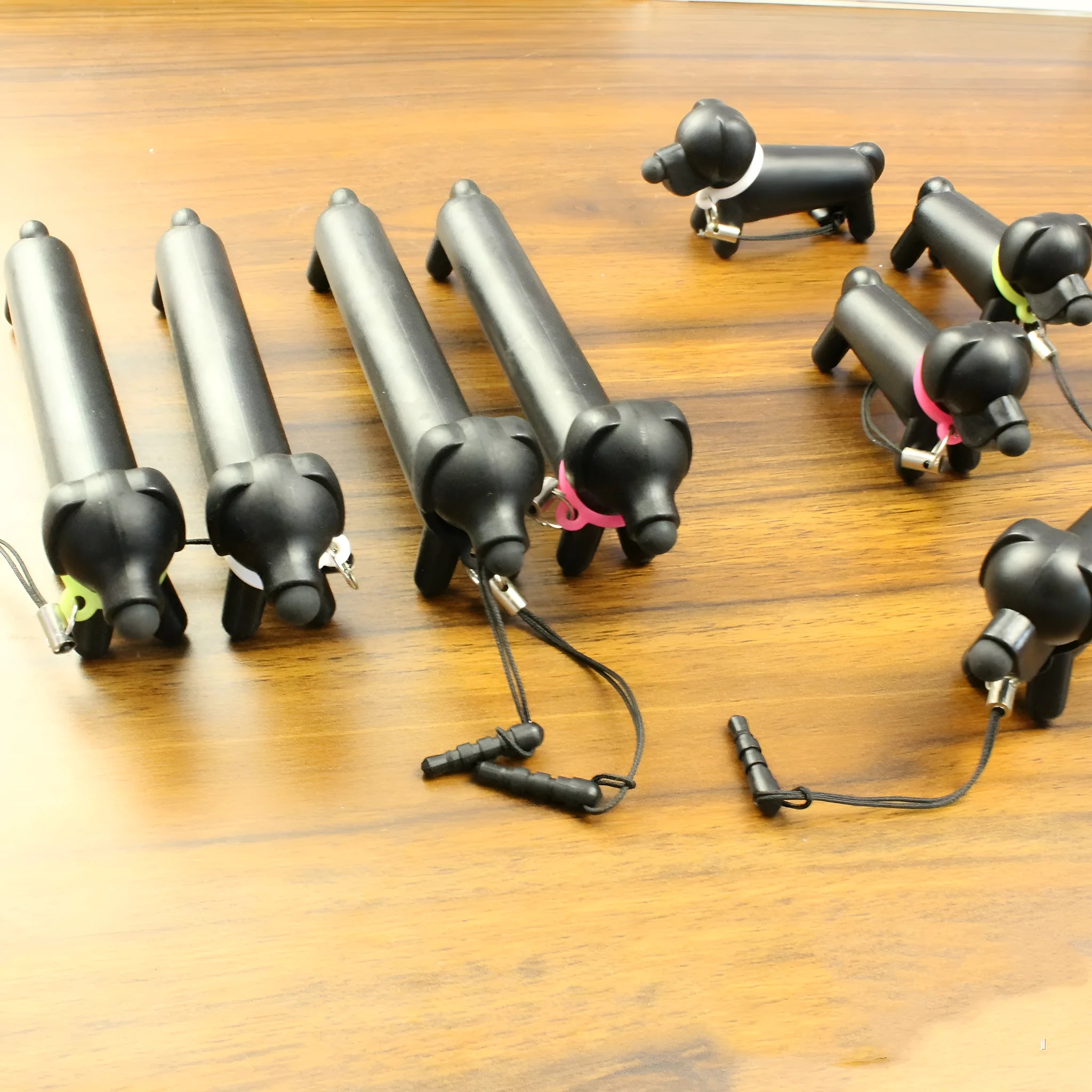 Black dog-shaped touch screen stylus showing split design for dual-length use and phone stand functionality