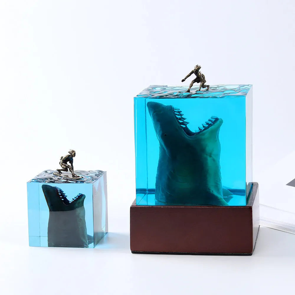 Clear epoxy resin ornament with a shark surfing scene inside, shown next to a 5cm and 8cm size option.