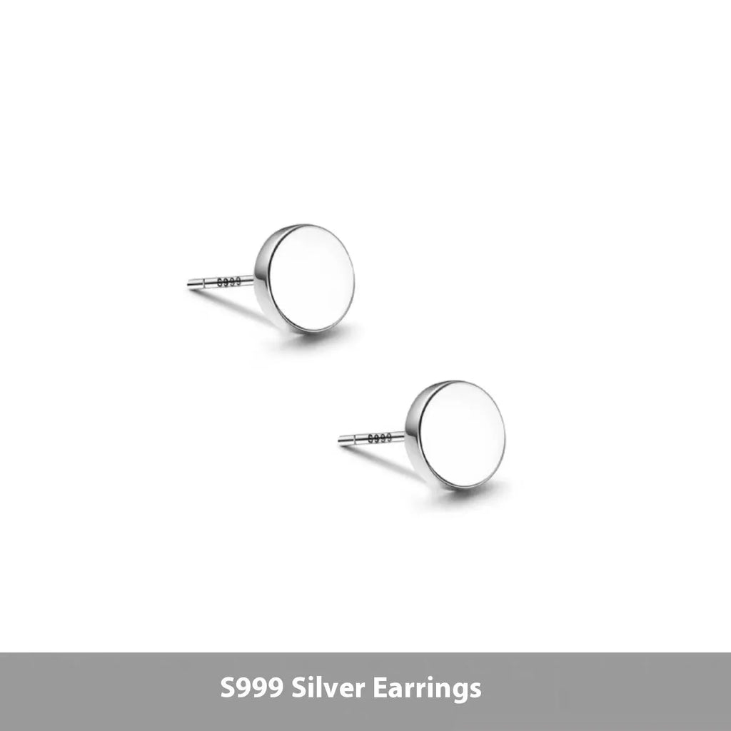 A pair of simple round sterling silver S999 stud earrings on a flat surface, shown in silver and black finishes.
