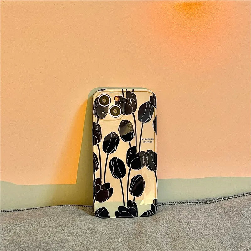 Black silicone iPhone case with a large tulip flower design on the back.
