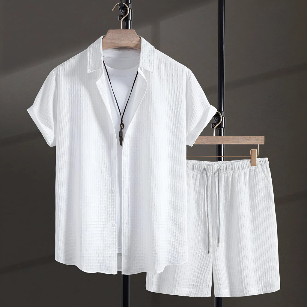 Men's loose-fitting cotton blend short sleeve shirt and shorts suit in black, laid flat.