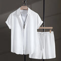 Men's loose-fitting cotton blend short sleeve shirt and shorts suit in black, laid flat.
