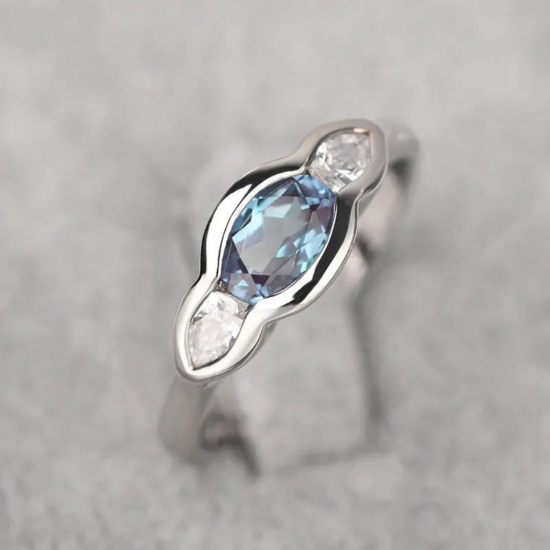 Geometric ellipse ring with inlaid zircon stones in white gold colour on female hand