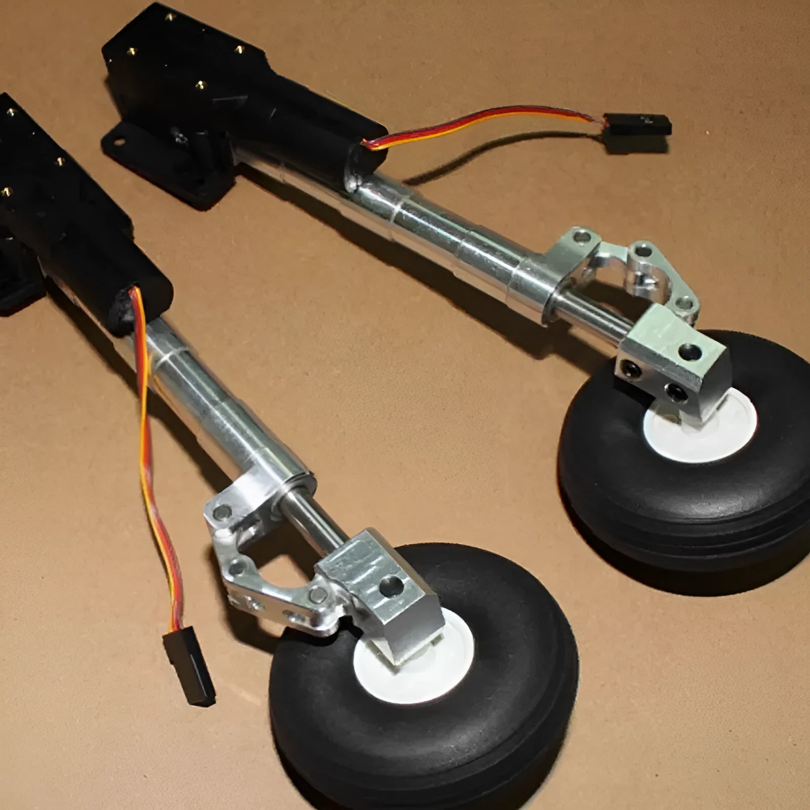 Alloy retractable shock-absorbing landing gear for RC cars with adjustable height and wheel options.
