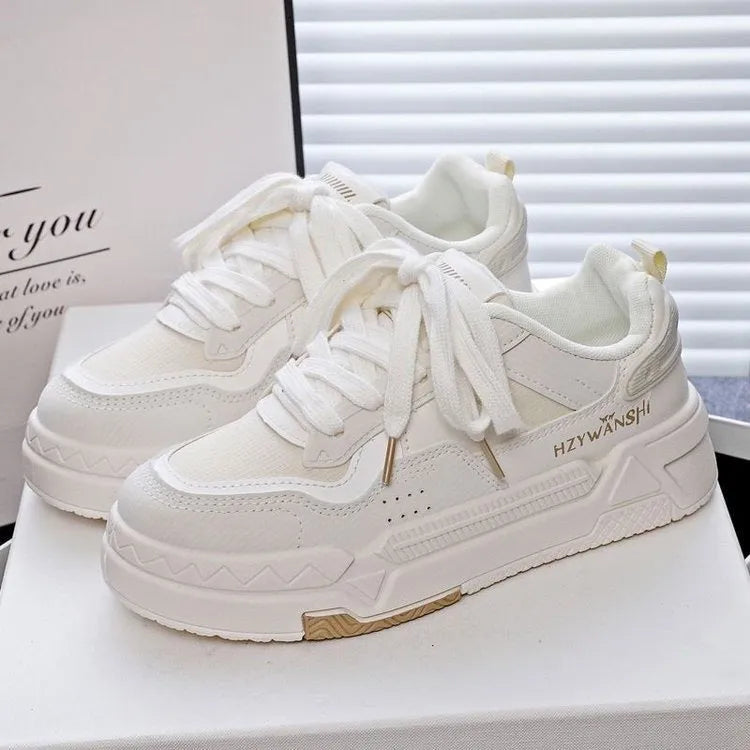 Children's beige board shoes with thick rubber sole, cross shoulder straps, and lace-up front.