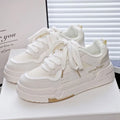Children's beige board shoes with thick rubber sole, cross shoulder straps, and lace-up front.