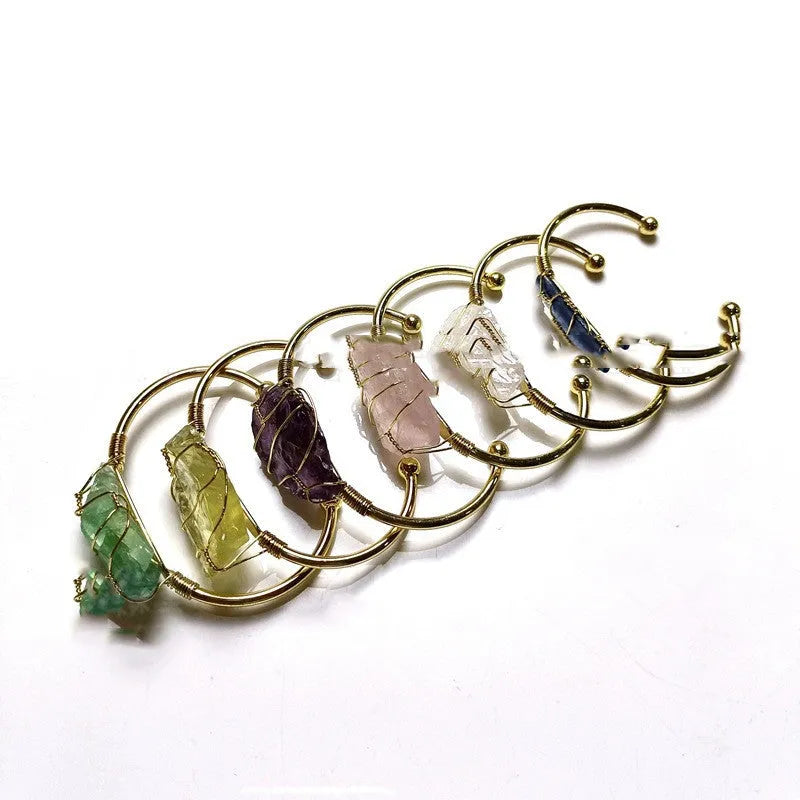 Unisex rough natural crystal bracelet with geometric gold metal winding on a wrist