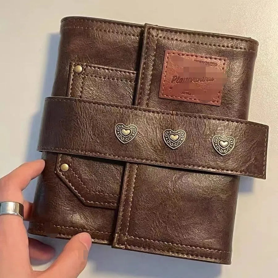 Brown retro-style notebook with leather buckle on PU cover, showing loose-leaf binder binding and A7 size