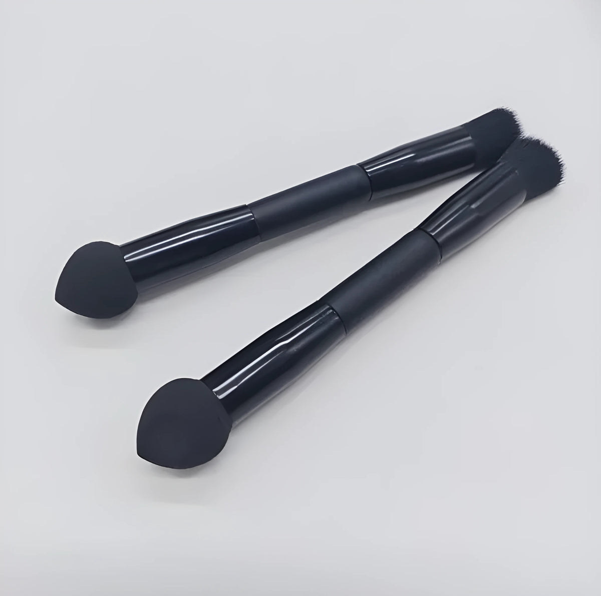 Elegant black double-headed concealer brush with miter sponge and synthetic bristles on a wooden handle.