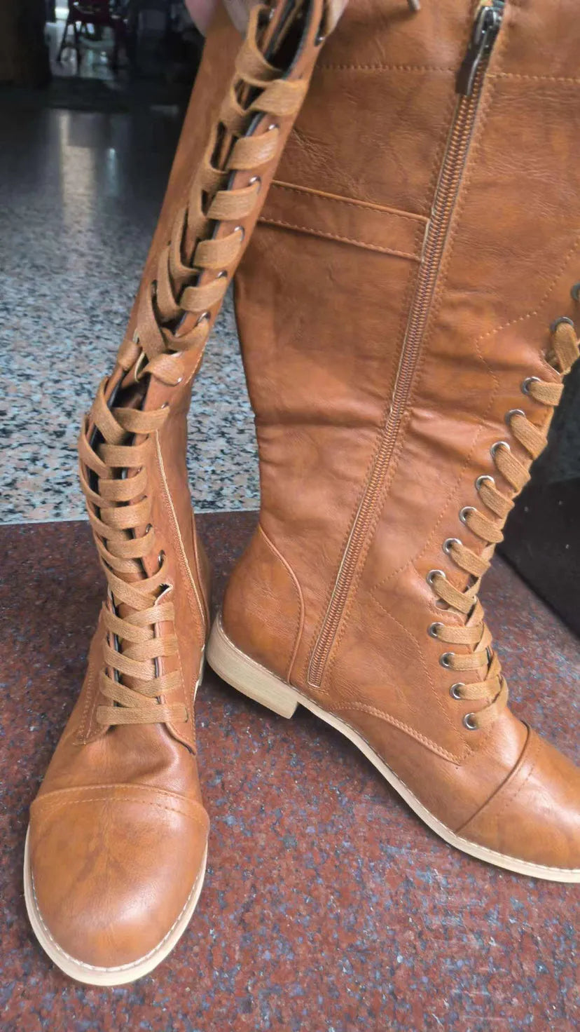 Women's black knight-style ankle boots with a cross-strap fastening across the front.