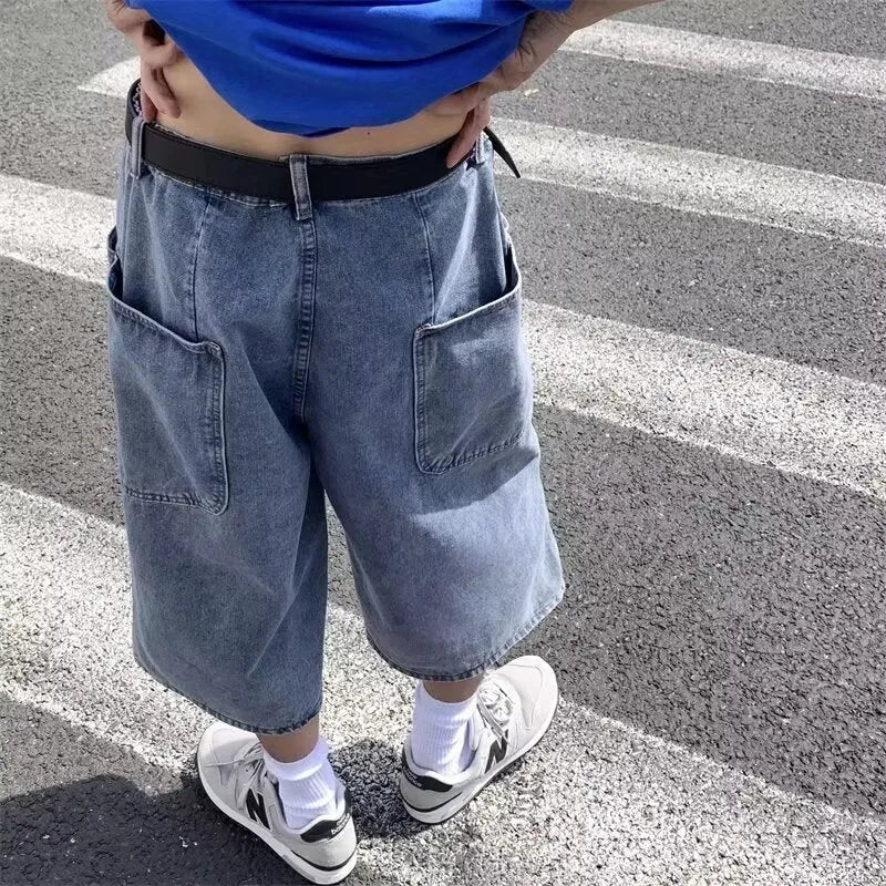Blue men's washed denim pirate shorts with a high waist and cropped length on a hanger.