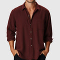 Man wearing a loose-fit solid colour long sleeve shirt with a stand collar, suitable for casual or holiday wear.