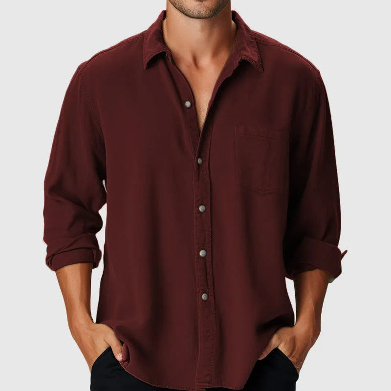 Man wearing a loose-fit solid colour long sleeve shirt with a stand collar, suitable for casual or holiday wear.