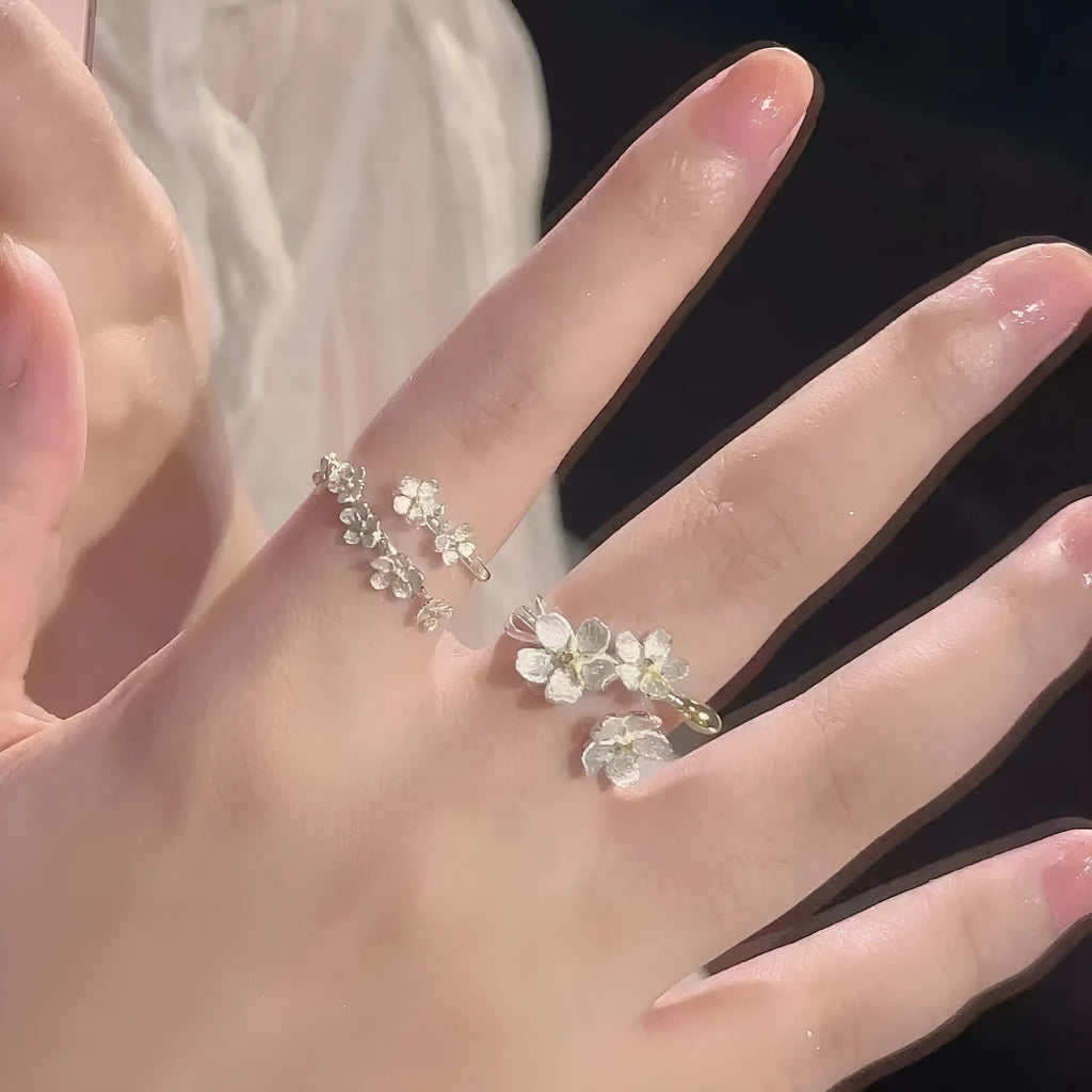 Three-dimensional jasmine flower ring with adjustable open mouth design in zinc alloy.