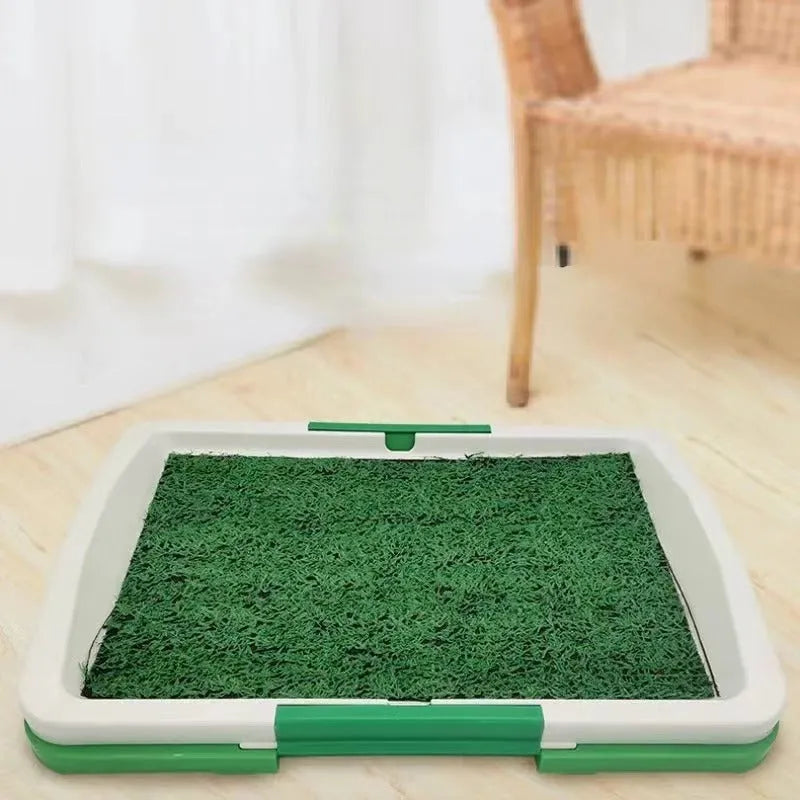 Green artificial turf dog toilet with removable plastic collection tray for indoor potty training.
