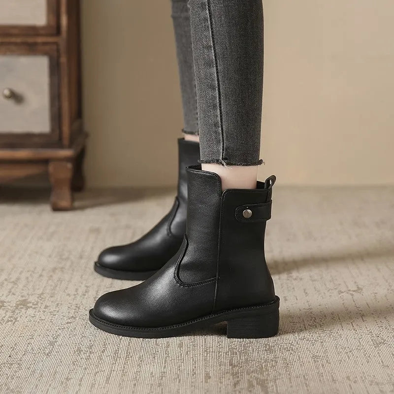 Black women's low heel ankle boots with side zip and round toe on a rubber sole