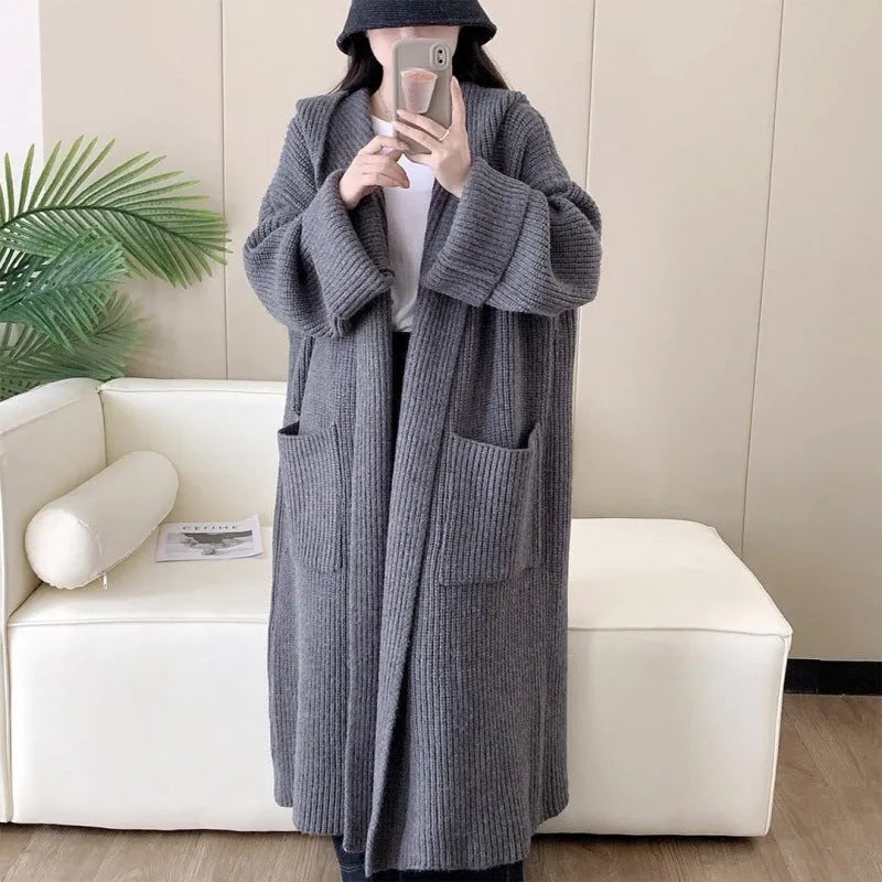 A woman wearing a longline milky white hooded cardigan sweatshirt with raglan sleeves.