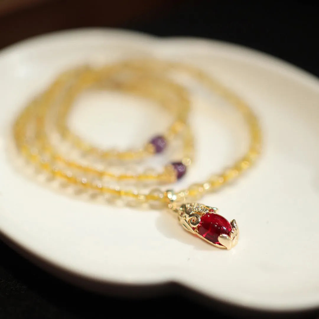 Brazil gold rutilated quartz bracelet with three gold circles in a Chinese style, hanging from chopsticks.