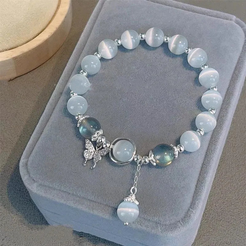 A Chinese style glass bracelet with bamboo leaf and bead designs on a wrist.