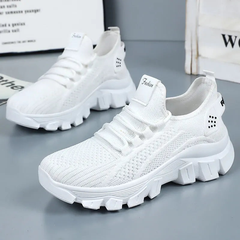 Women's white Flyknit sneakers with a thick PVC sole and lace-up front.