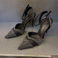 Women's black high heel shoe with stiletto heel, pointed toe, shallow cut, and red sole.