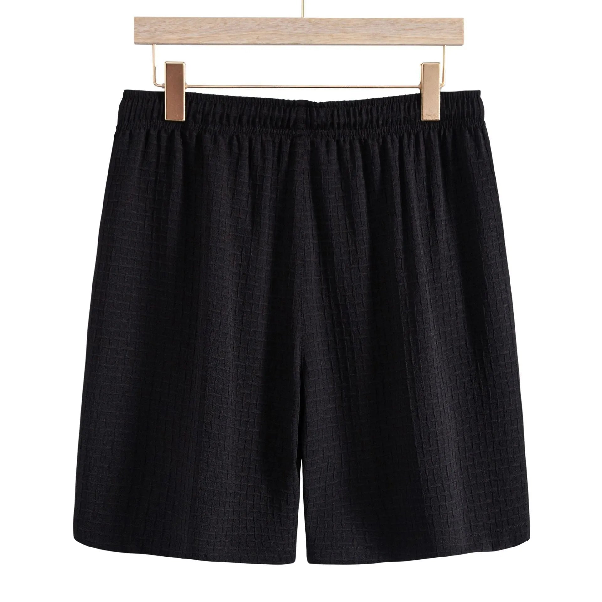 Men's loose-fitting cotton blend short sleeve shirt and shorts suit in black, laid flat.