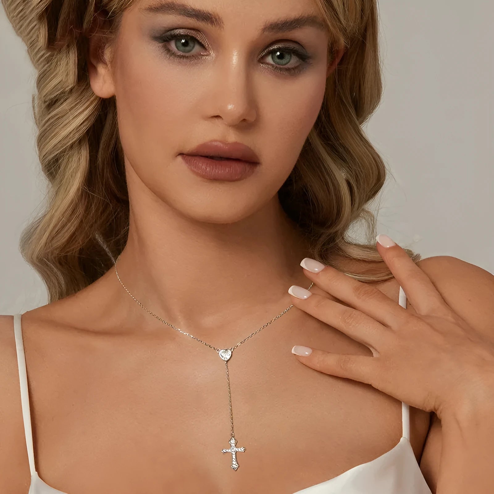 Close-up of a silver love cross necklace with an adjustable O-ring chain on an antique BSN384 finish.