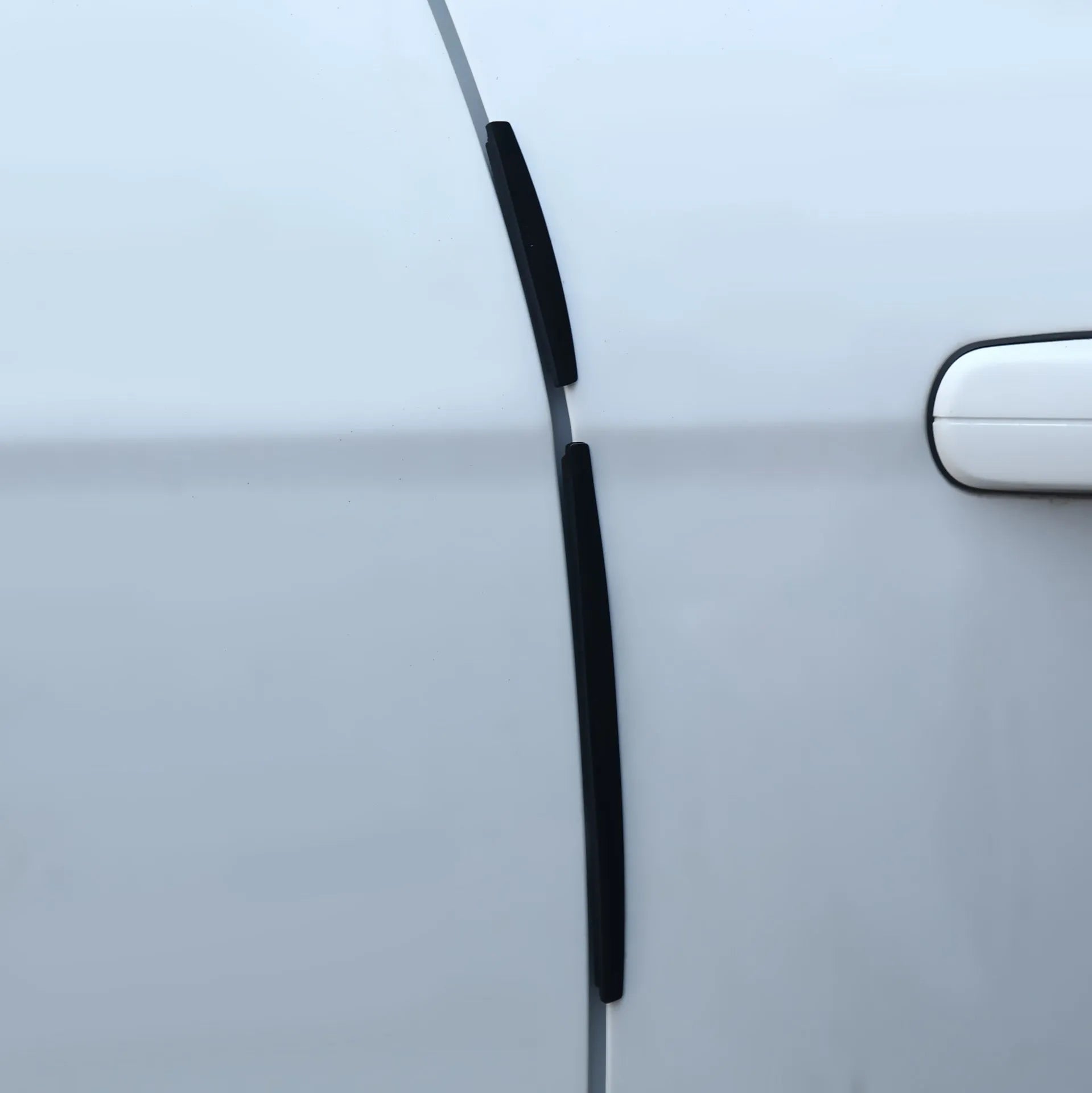 Solid white plastic car door side bumper strip for edge protection.