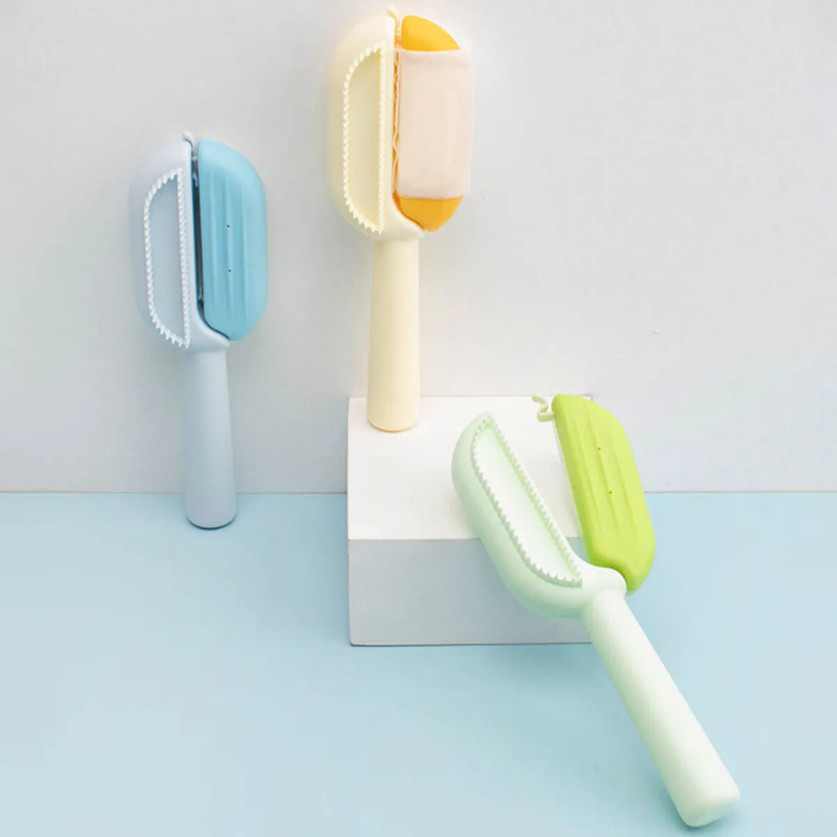 Blue pet grooming comb with water tank and four comb head types.