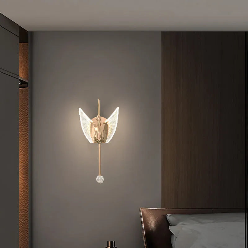 Gold modern swan wall lamp with acrylic shade mounted beside bed