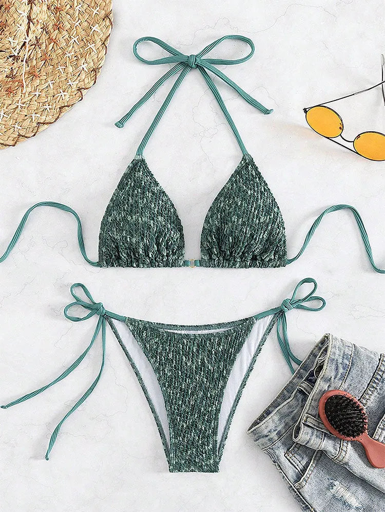 Green women's backless halter strap bikini set with matching shorts on a mannequin.