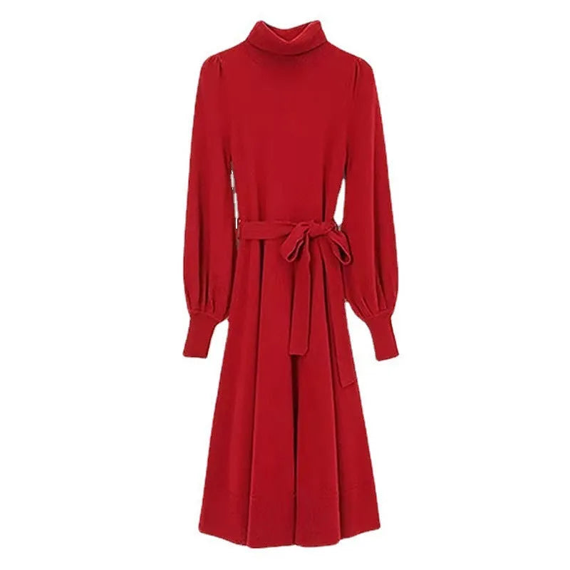 A woman wearing a rose red knitted turtleneck sweater dress with long sleeves, an elastic waist, and a loose, big hem.