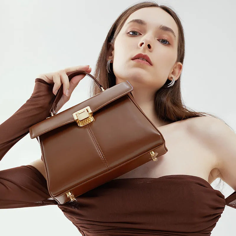 Black genuine leather shoulder bag with clasp closure showing internal compartments and adjustable strap