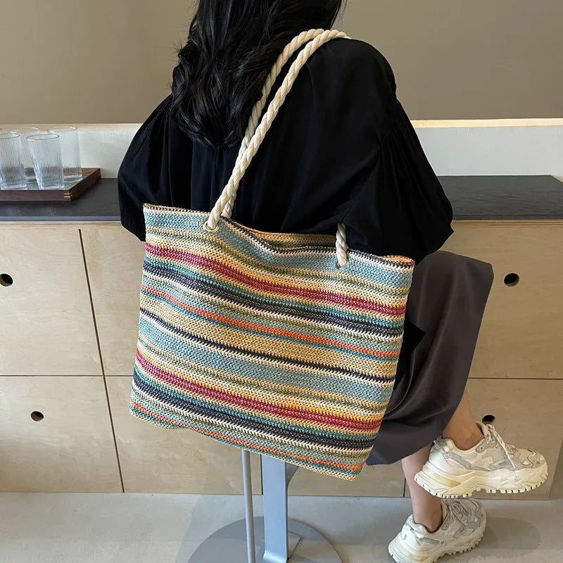 Blue straw-woven nylon shoulder bag with a single strap and large main compartment.