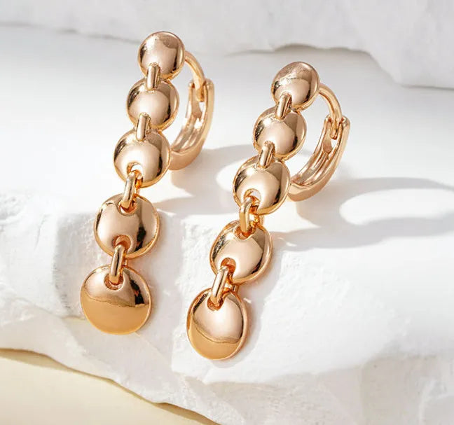 Retro long round copper earrings with woven design in a gold colour finish.