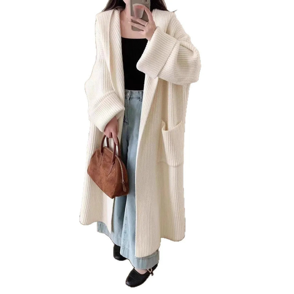 A woman wearing a longline milky white hooded cardigan sweatshirt with raglan sleeves.
