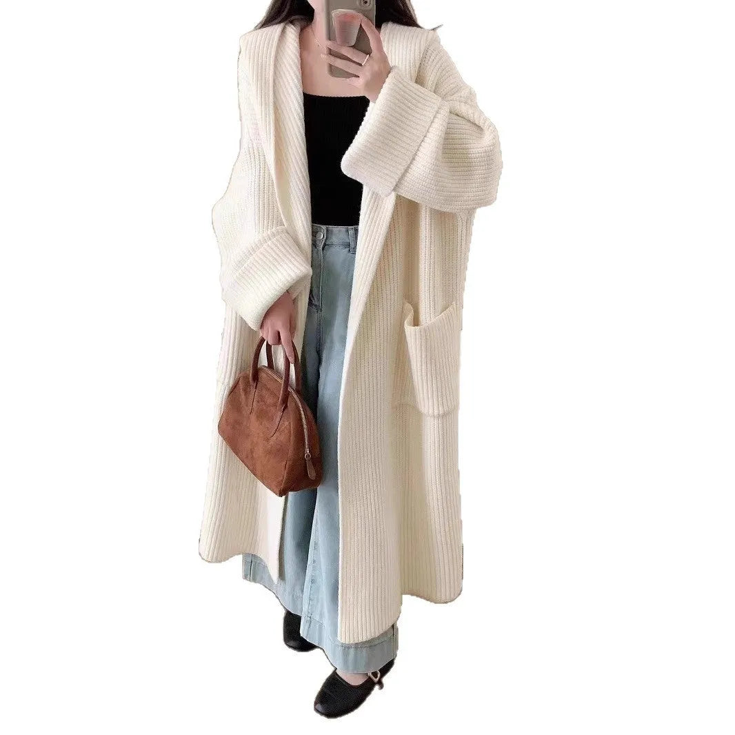 A woman wearing a longline milky white hooded cardigan sweatshirt with raglan sleeves.