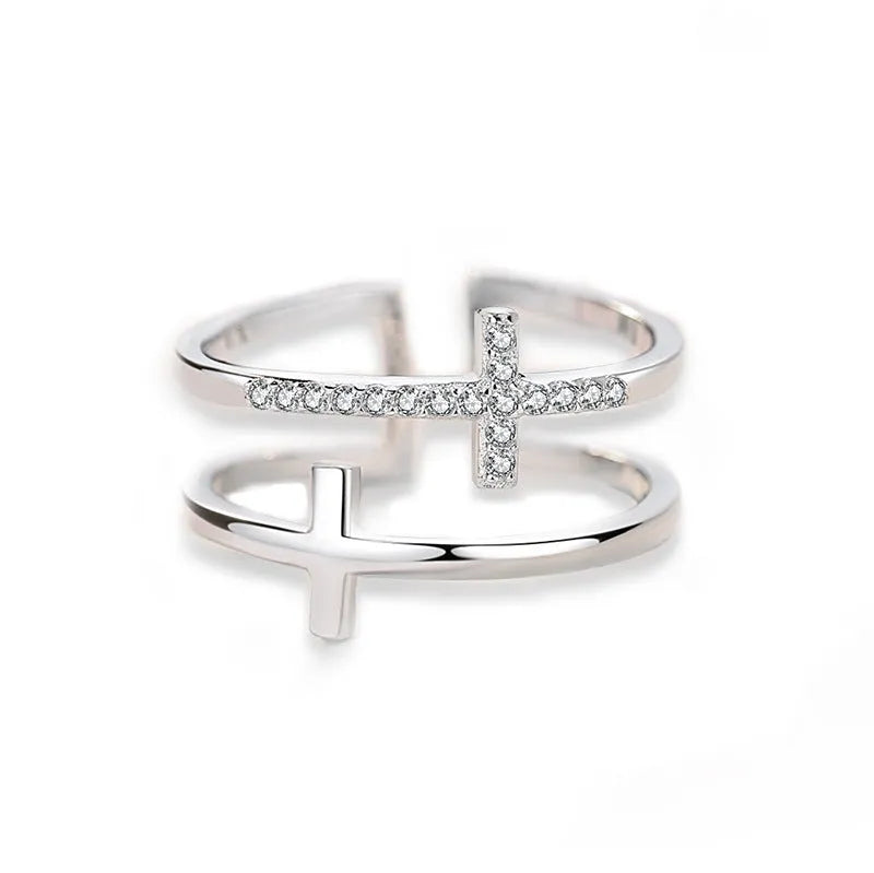 Adjustable open ring showing double cross design with zircon stones and sterling silver inlay on copper.