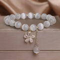 White cat's eye stone women's bracelet with flower tassel and morganite safety buckle pendant.