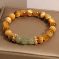 Natural Yellow Tiger's Eye and Hetian Jade beaded bracelet with gold gourd or bamboo joint design.