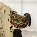 Women's woven straw crossbody bag showing internal phone and document compartments