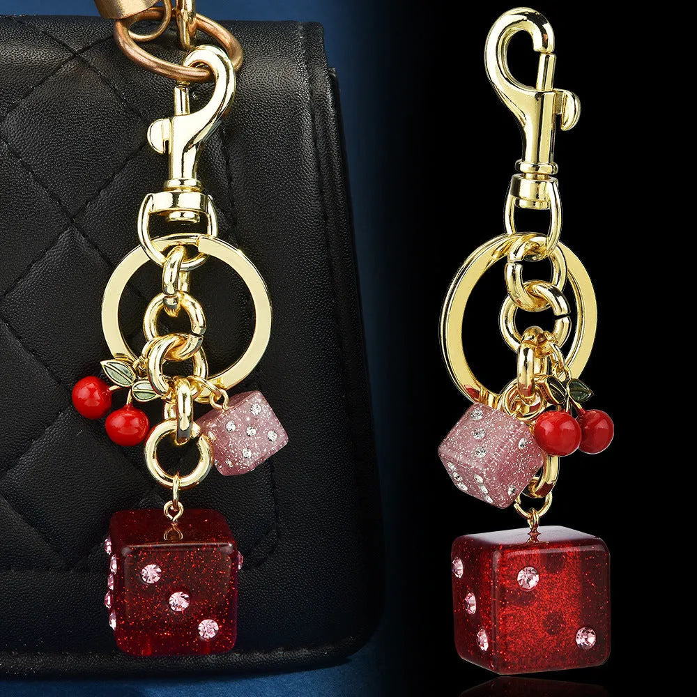 Square metal keychain pendant with a vintage cherry two-colour dice design.