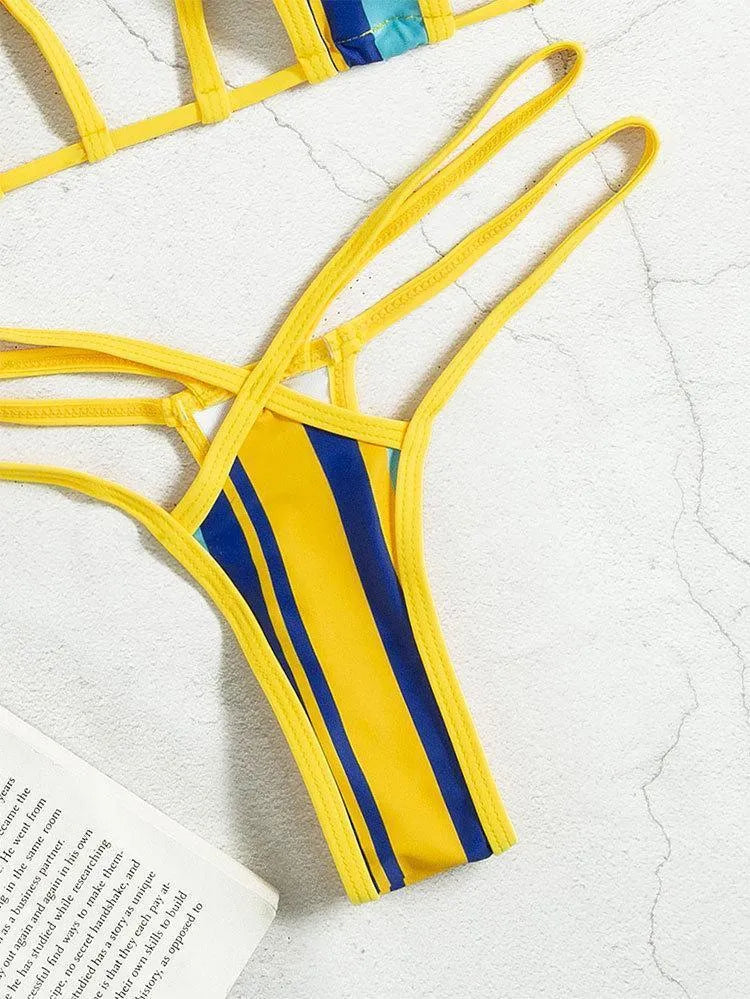 Yellow women's two-piece swimsuit with high-waisted shorts and a sleeveless, backless top on a neutral background.