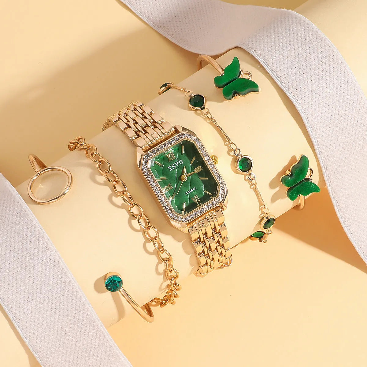Gold green square women's watch with four matching bracelets on display