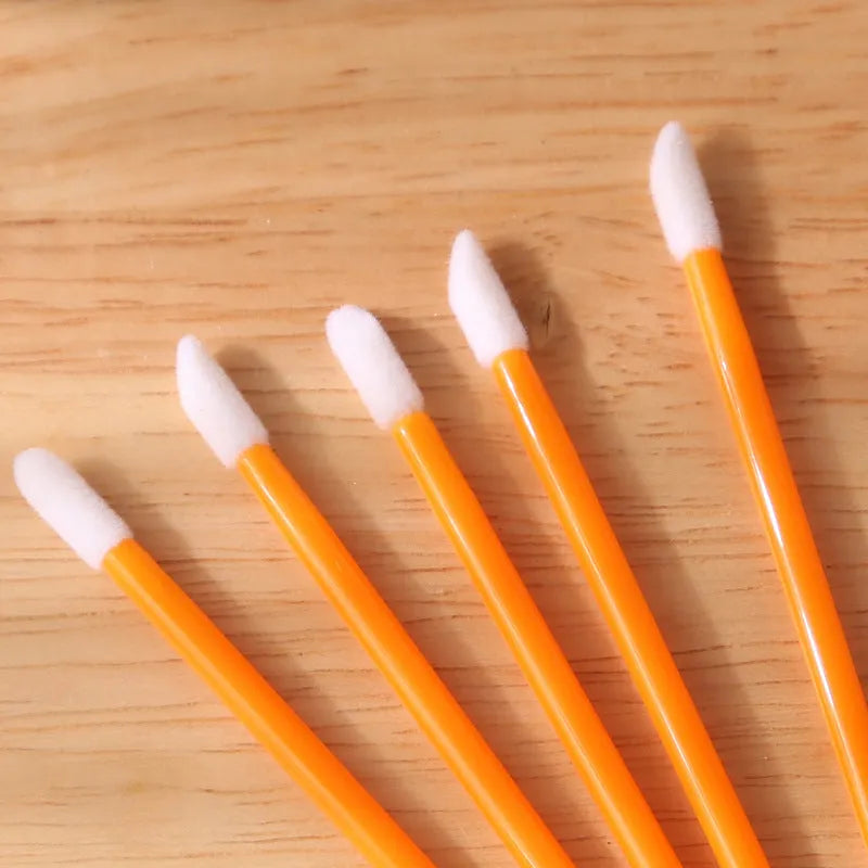 Disposable lip brushes with black handles and flocked tips in bulk packaging for lipstick and gloss application
