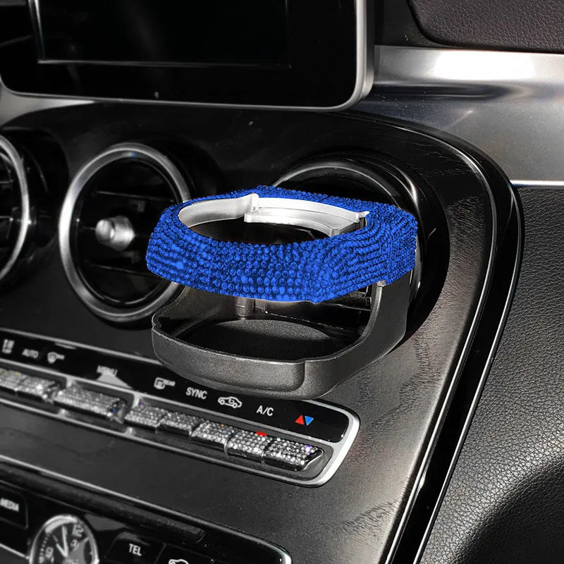 Sparkling rhinestone car cup holder bracket clipped to a vehicle air vent, shown in pink diamond colour.