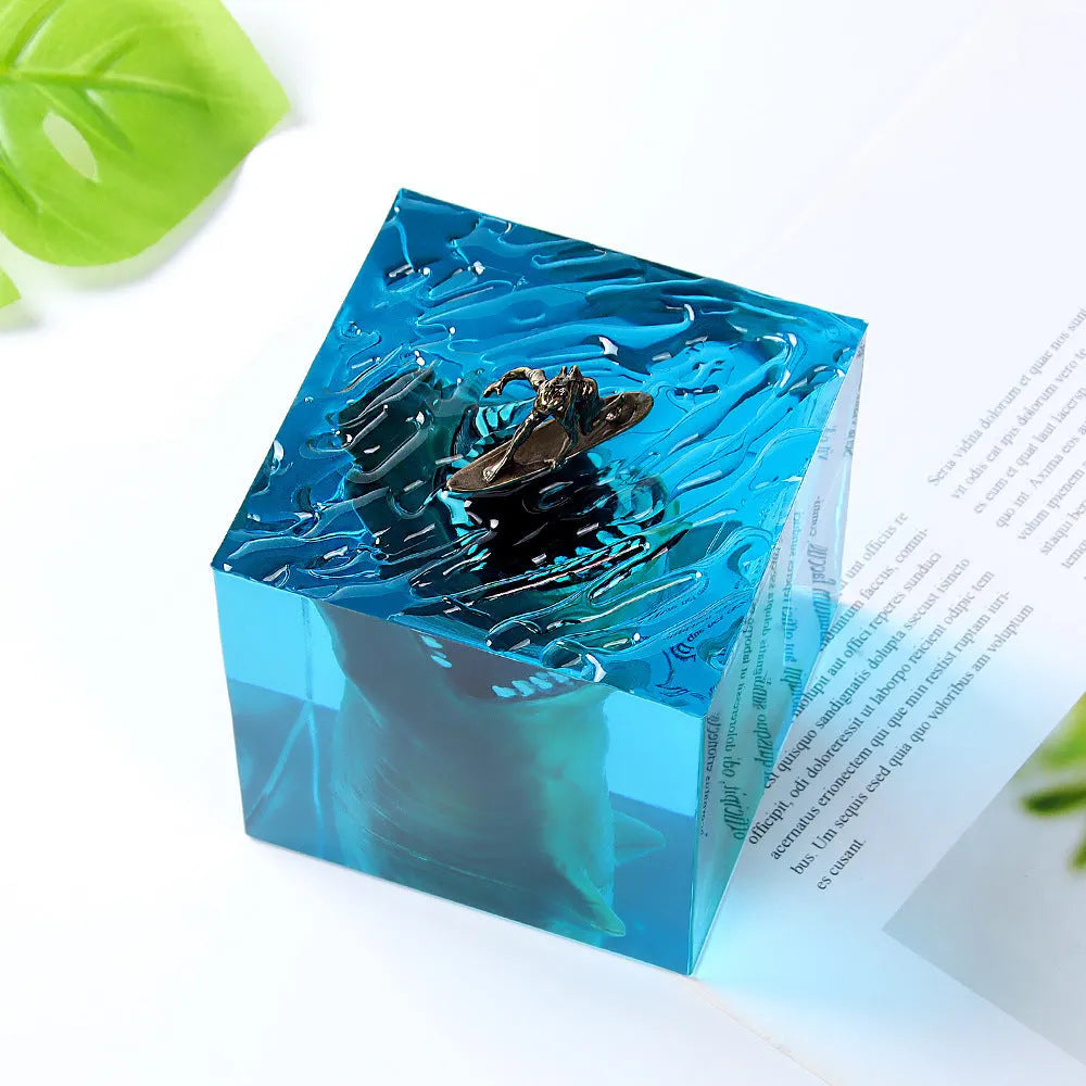 Clear epoxy resin ornament with a shark surfing scene inside, shown next to a 5cm and 8cm size option.