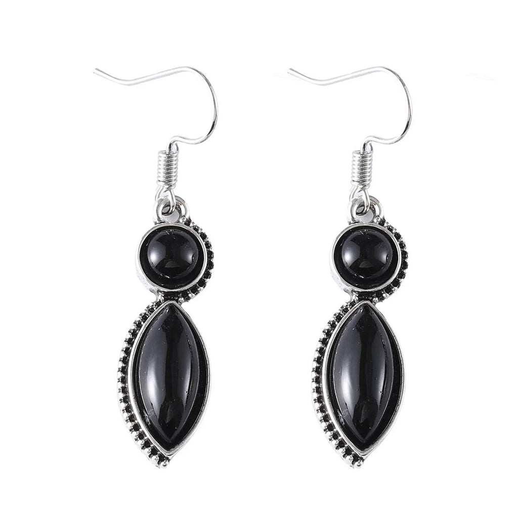 A pair of vintage geometric drop earrings with black and purple stones in a bohemian style.