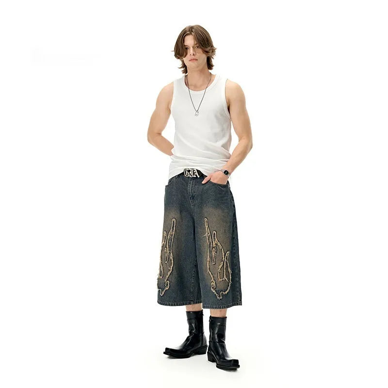 Men's black cropped denim shorts with flame embroidery patch and straight-leg cut