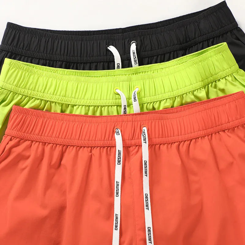 Men's loose-fit beach surf shorts in polyester available in orange, green or black colours